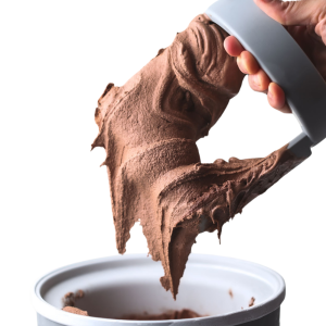 Classic chocolate ice cream made with xanthan gum being lifted from a container, smooth and stretchy texture